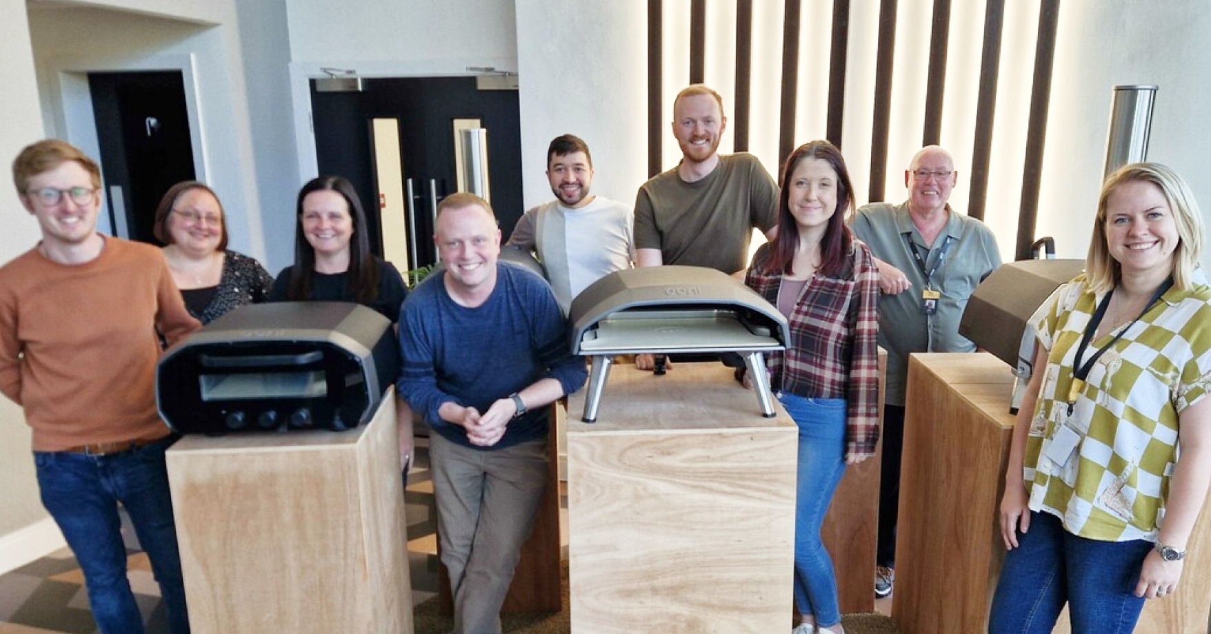 The Ooni team standing next to their pizza ovens